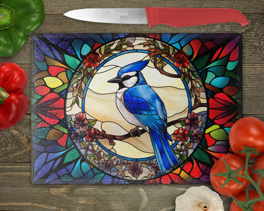 a blue bird sits on a stained glass cutting board